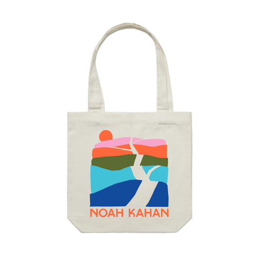 Natural canvas Noah Kahn Trails tote back with five color layered artwork of hills and branching roads and an orange sunset. 